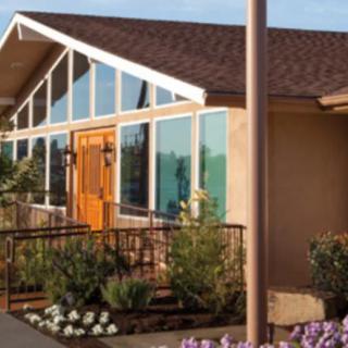 A modern house with large windows and a landscaped front porch.