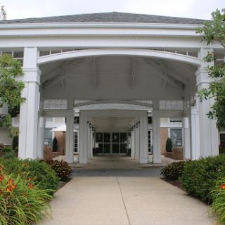 A modern building entrance framed by lush landscaping.
