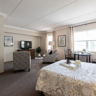 Spacious bedroom with seating area and modern decor.