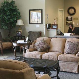 A cozy waiting area with comfortable sofas, a lamp, and decor elements.