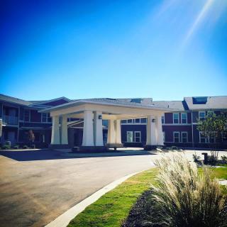A modern building with a grand entrance under a clear blue sky.