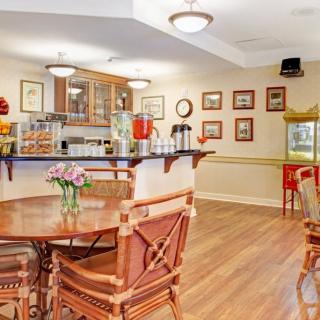 A cozy cafe interior with wooden tables and chairs, adorned with decorative elements and warm lighting.