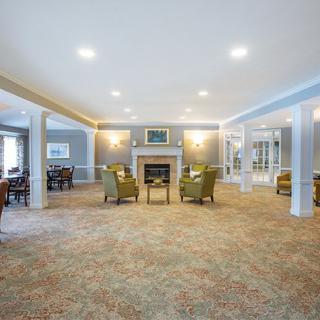 A spacious living room with comfortable seating and a central fireplace.