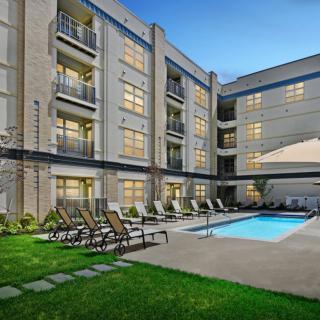 Modern residential complex with a swimming pool and outdoor lounge area.