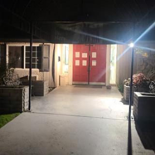 A welcoming entrance illuminated at night with prominent red doors.