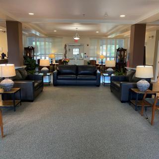 A spacious lobby area with sofas, tables, and lamps arranged symmetrically.