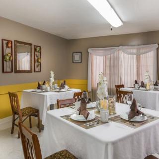 A neatly arranged dining room with decorated tables, chairs, and bright lighting.