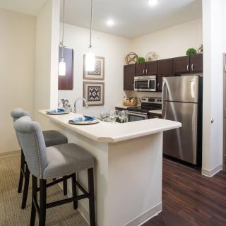 A modern kitchen with stainless steel appliances and a breakfast bar.
