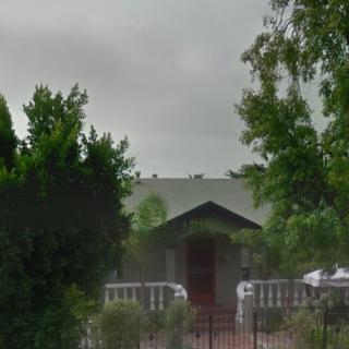 A quaint house surrounded by trees on an overcast day.