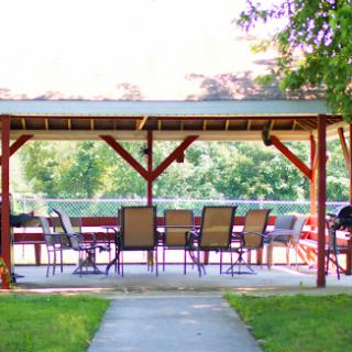A serene outdoor pavilion with seating, perfect for relaxation by the water.