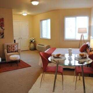 A cozy and modern apartment interior featuring a small dining area and comfortable seating.