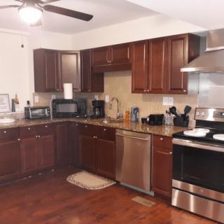 A modern kitchen with dark wood cabinets and stainless steel appliances.