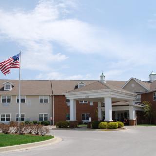 An entrance to a building with an American flag and a driveway.