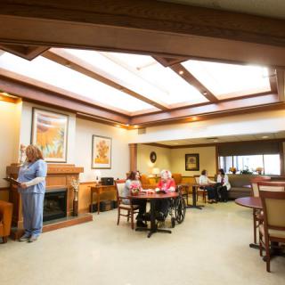 A cozy lounge area with people seated and socializing, featuring comfortable furniture and warm lighting.