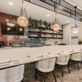 Contemporary restaurant interior with stylish bar seating and modern lighting.