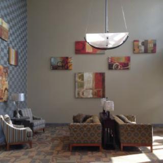 A stylish lobby area featuring modern furniture and artwork on the walls.