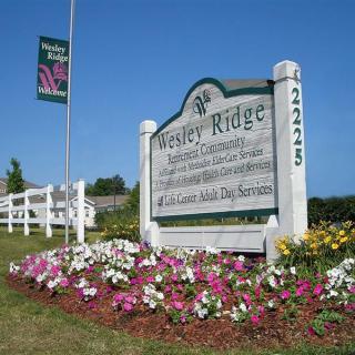 Entrance sign to Wesley Ridge surrounded by a colorful flower bed.