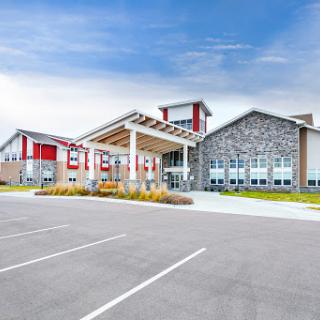 A modern educational facility showcasing contemporary architecture and ample parking.