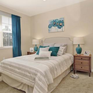 A cozy bedroom with neutral colors and blue accents.