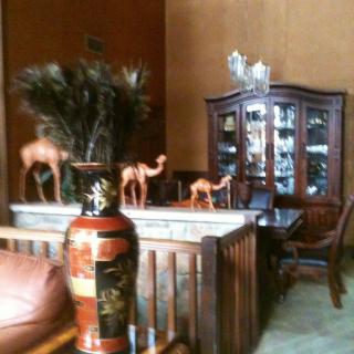 A cozy living room featuring decorative camels, a painted vase, and a wooden cabinet.