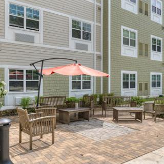 A cozy outdoor patio area with seating and a sunshade, perfect for relaxation.