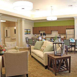 A modern open-concept living and dining area with a kitchen in the background.