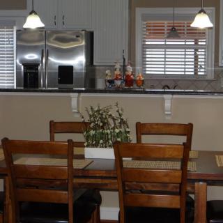 A cozy kitchen and dining area with wooden furniture and modern appliances.
