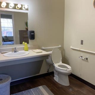 A clean and well-lit bathroom with a sink and toilet setup.