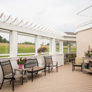 A serene outdoor patio with comfortable seating and lush surroundings.