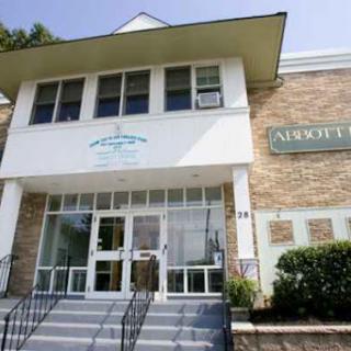 A modern two-story building with a welcoming entrance and landscaped surroundings.