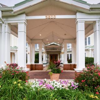 A beautiful entrance featuring classic architecture and vibrant landscaping.