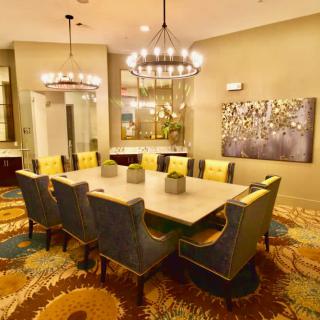 A modern dining room with a chandelier, stylish table, and comfortable seating.