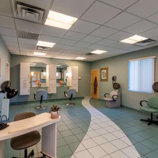 A modern hair salon interior with chairs and mirrors.