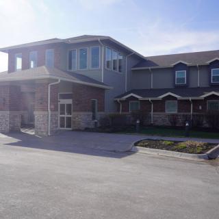 A suburban residential building with a driveway and front yard.
