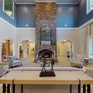 Spacious living room with high ceilings and a central fireplace.