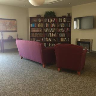 A cozy library corner featuring a bookshelf filled with books and comfortable seating.