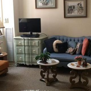 A cozy living room with a blue sofa, television, and decorative coffee tables.