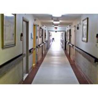 A hospital corridor with rooms on either side.