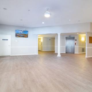 A spacious and well-lit reception area with modern flooring and an elevator.