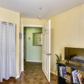 A cozy bedroom with a bookshelf and an open door leading to a hallway.