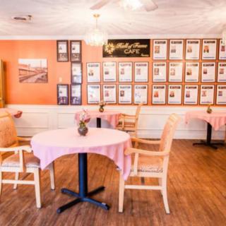 A cozy restaurant dining area with tables and chairs, featuring wall decor.