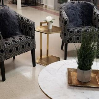 A stylish living room setup featuring patterned armchairs and a round table with decorative plants.