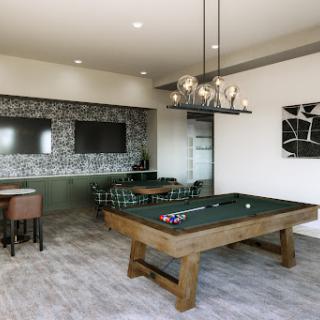 A stylish game room featuring a pool table, comfortable seating, and modern decor.