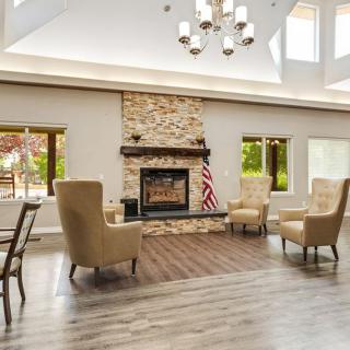 A cozy living room with a stone fireplace and elegant seating.
