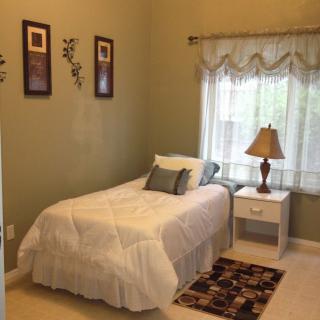 A cozy bedroom with a single bed, nightstand, and decorative elements.