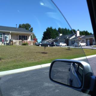 A view of a suburban neighborhood with houses lined up under a clear blue sky.