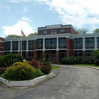 A modern educational or institutional building surrounded by well-maintained landscaping.