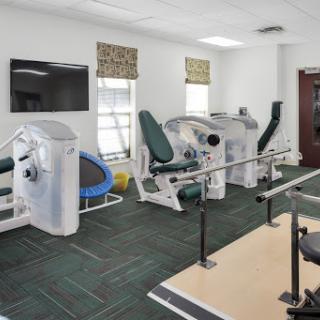 A well-equipped rehabilitation gym featuring various exercise machines for physical therapy.