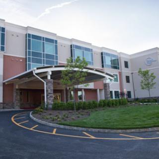 A modern healthcare facility featuring a spacious entrance and landscaped surroundings.