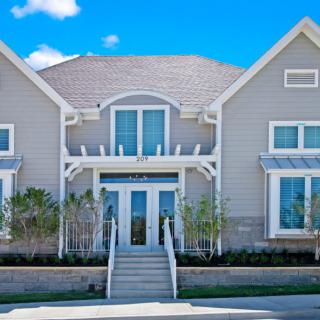 A modern residential house with a symmetrical facade and large windows.